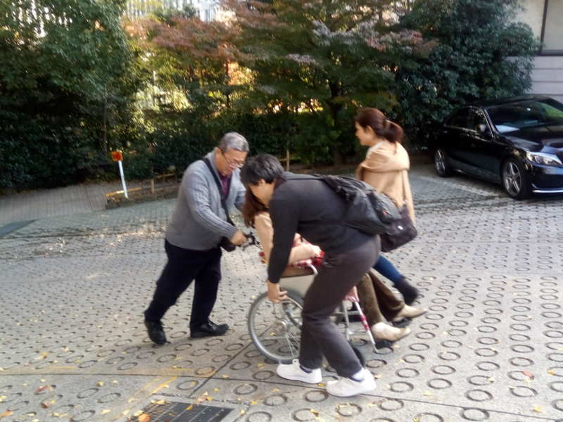 日枝神社横の坂道にて車椅子のサポート